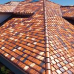 Luxurious home with a vibrant mosaic tile roof under a clear blue sky.